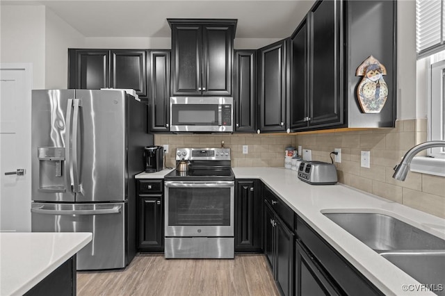 kitchen featuring a sink, dark cabinets, and stainless steel appliances