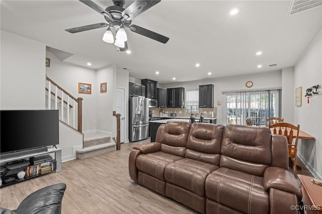 living room with visible vents, recessed lighting, stairway, light wood-style floors, and baseboards