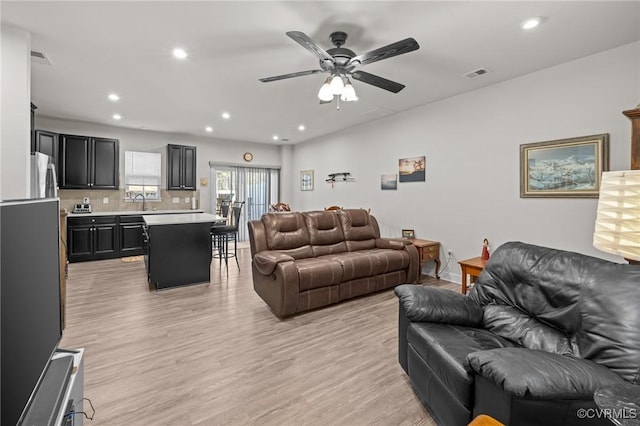 living area with a ceiling fan, recessed lighting, light wood-style floors, and visible vents