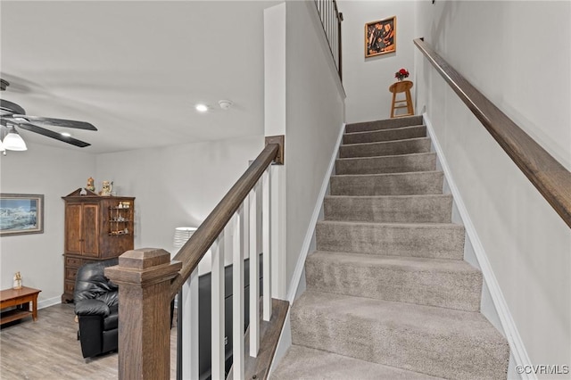 stairway with baseboards, ceiling fan, and wood finished floors