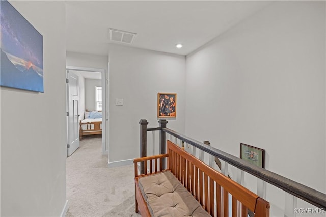 hall featuring baseboards, visible vents, recessed lighting, light carpet, and an upstairs landing