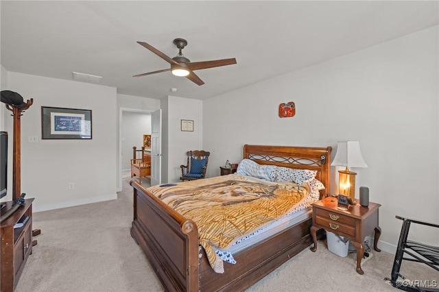 bedroom with a ceiling fan, light colored carpet, and baseboards