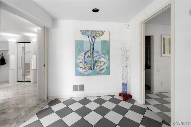 corridor with tile patterned floors, baseboards, and visible vents