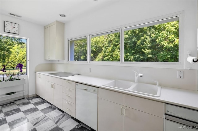 kitchen with light countertops, visible vents, white dishwasher, and a sink