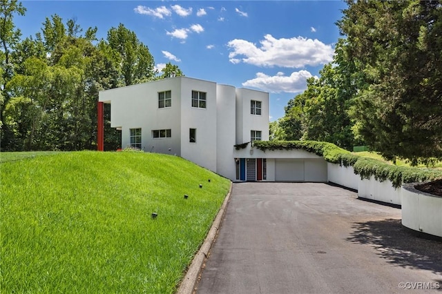 view of front of property featuring a front yard, a garage, and stucco siding