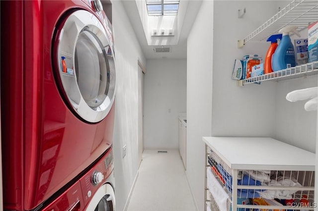 laundry room featuring laundry area, stacked washer and clothes dryer, and visible vents