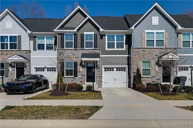 view of property with driveway, an attached garage, a shingled roof, stone siding, and board and batten siding