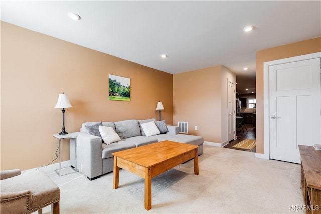 living area featuring recessed lighting, visible vents, light colored carpet, and baseboards