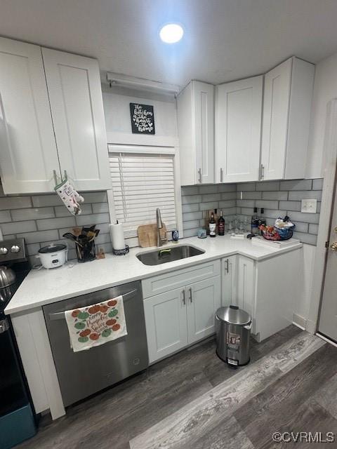 kitchen featuring a sink, dishwasher, light countertops, and white cabinetry