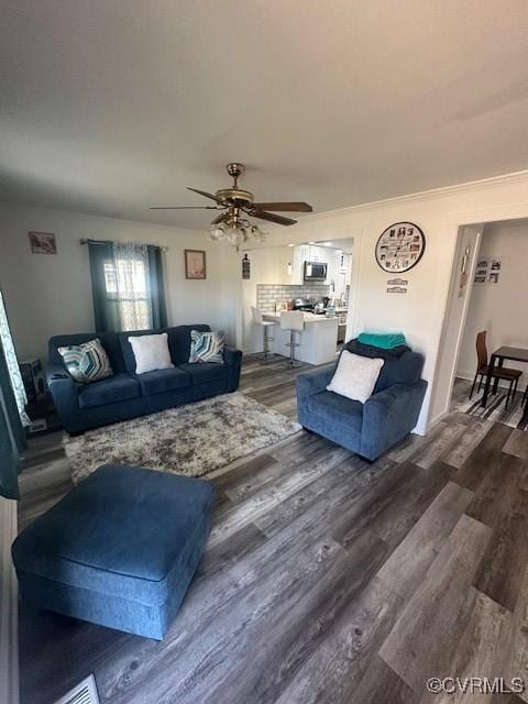 living area featuring ceiling fan and dark wood finished floors