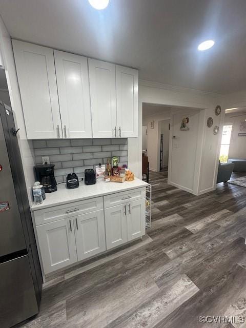 kitchen with white cabinetry, light countertops, dark wood-style flooring, and freestanding refrigerator