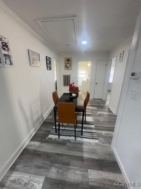 dining area featuring attic access, wood finished floors, crown molding, and baseboards