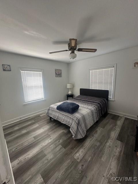 bedroom featuring baseboards, wood finished floors, and a ceiling fan