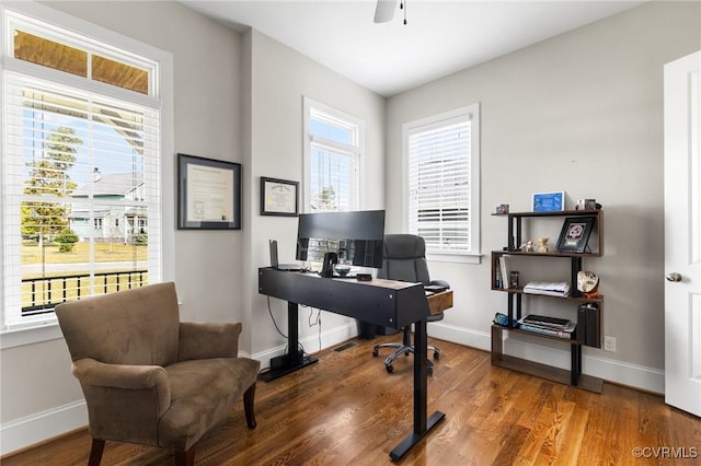 office space with baseboards, plenty of natural light, and wood finished floors