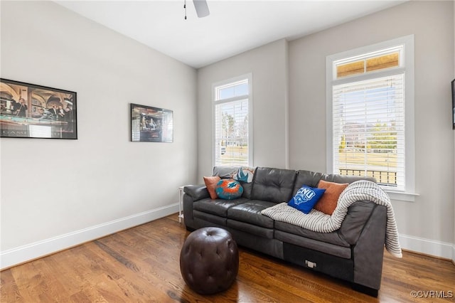 living room featuring wood finished floors, baseboards, and ceiling fan