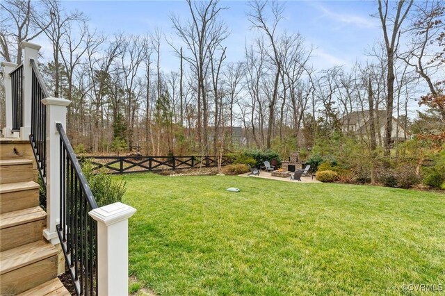 view of yard with a patio, stairway, a fire pit, and fence