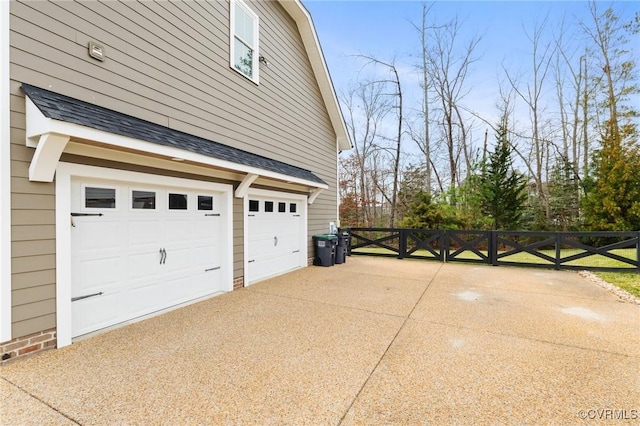 view of home's exterior with a garage, roof with shingles, concrete driveway, and fence