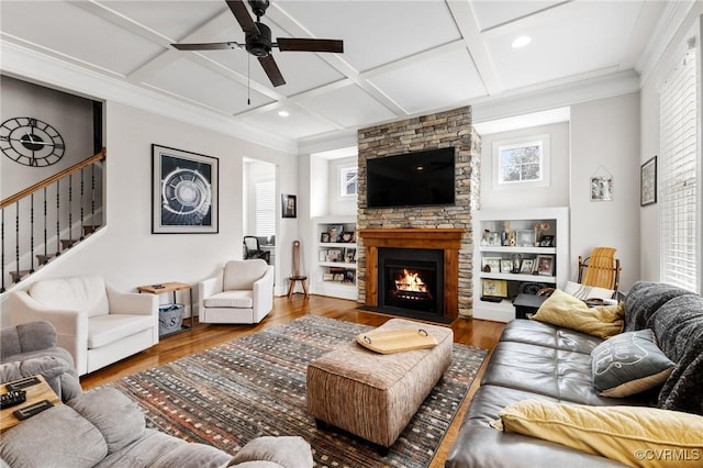 living area with a wealth of natural light, coffered ceiling, a fireplace, and wood finished floors