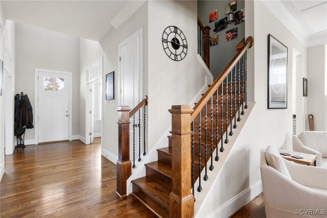 entryway with baseboards, wood finished floors, and stairs