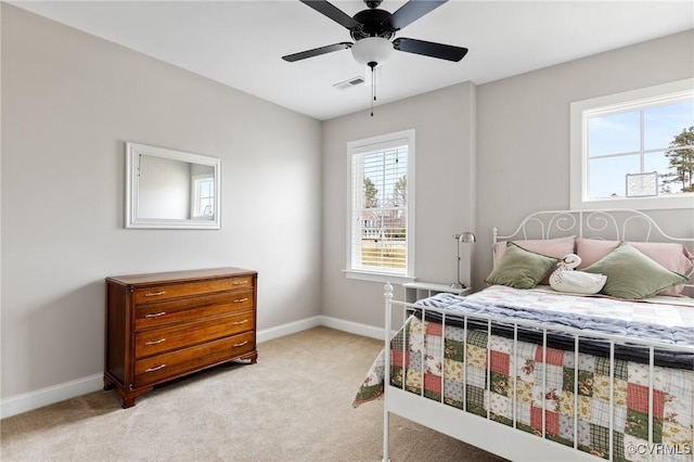 bedroom featuring baseboards, multiple windows, and light colored carpet