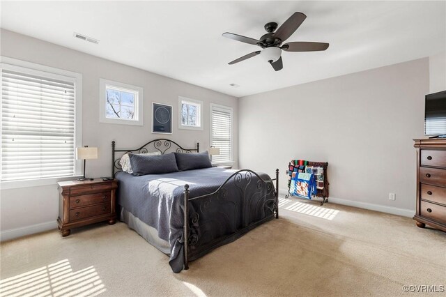 bedroom featuring visible vents, baseboards, light colored carpet, and a ceiling fan