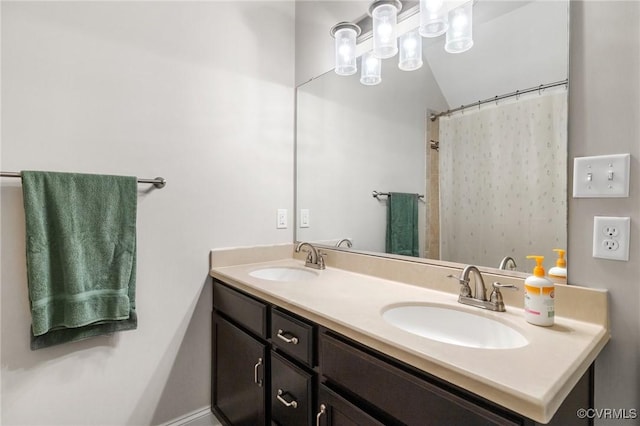 bathroom with double vanity, vaulted ceiling, a shower with shower curtain, and a sink