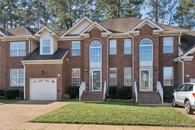 view of front of property featuring brick siding, concrete driveway, a front lawn, and a shingled roof