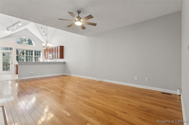 unfurnished living room with visible vents, rail lighting, light wood-type flooring, and baseboards