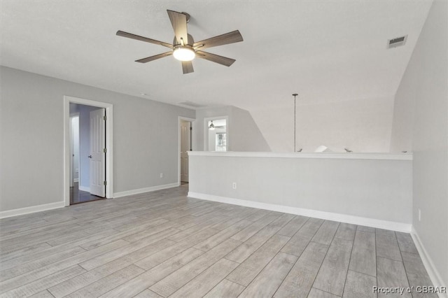 empty room featuring baseboards, wood finished floors, visible vents, and ceiling fan