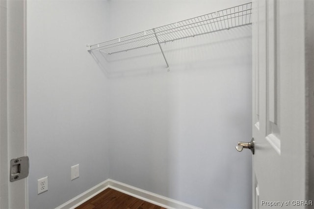 spacious closet with dark wood-style floors