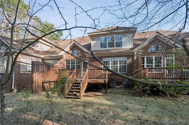 back of property featuring a wooden deck, brick siding, and stairs