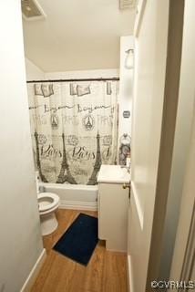 full bath featuring shower / bath combo with shower curtain, toilet, wood finished floors, and vanity