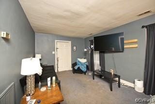 living area featuring visible vents, radiator heating unit, and carpet