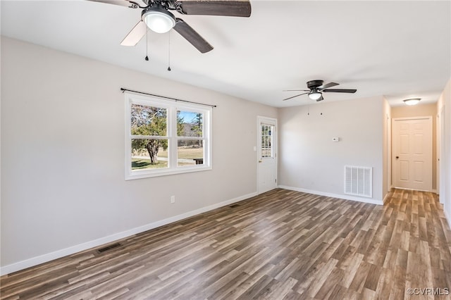 spare room with wood finished floors, baseboards, and visible vents