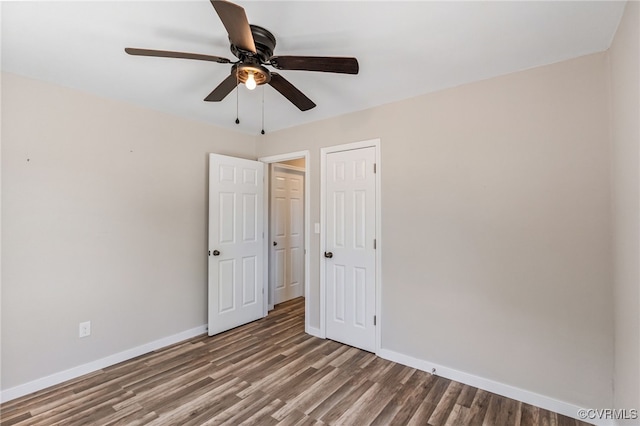 unfurnished bedroom with a closet, baseboards, wood finished floors, and a ceiling fan