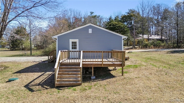 rear view of property with a wooden deck and a yard