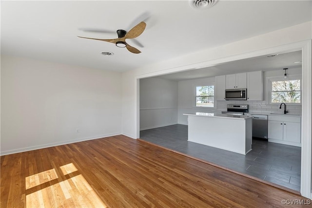 kitchen with visible vents, a sink, decorative backsplash, light countertops, and stainless steel appliances