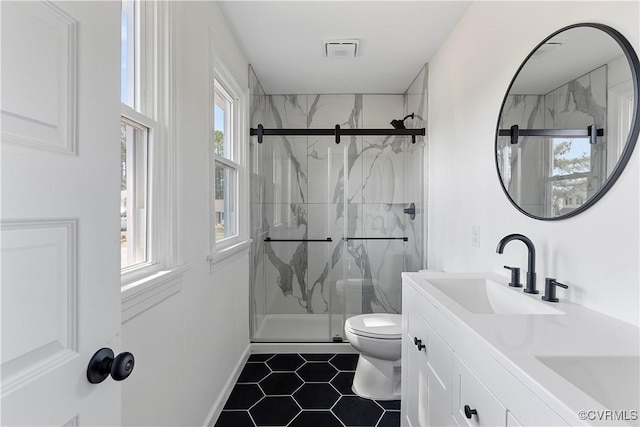 bathroom with toilet, visible vents, a marble finish shower, and a sink