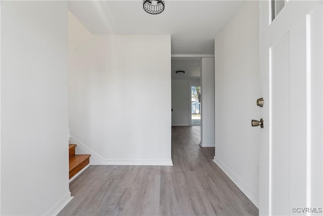 hall with baseboards, wood finished floors, and stairs