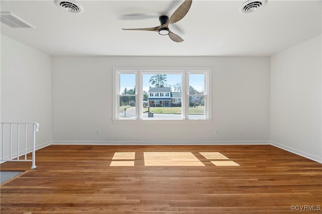 unfurnished room with wood finished floors and visible vents