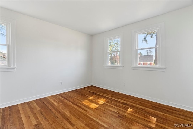 unfurnished room with baseboards and wood finished floors