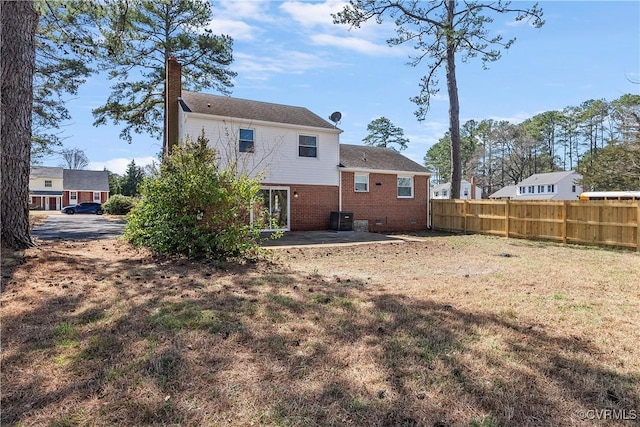 back of property featuring brick siding, fence, a chimney, crawl space, and a patio