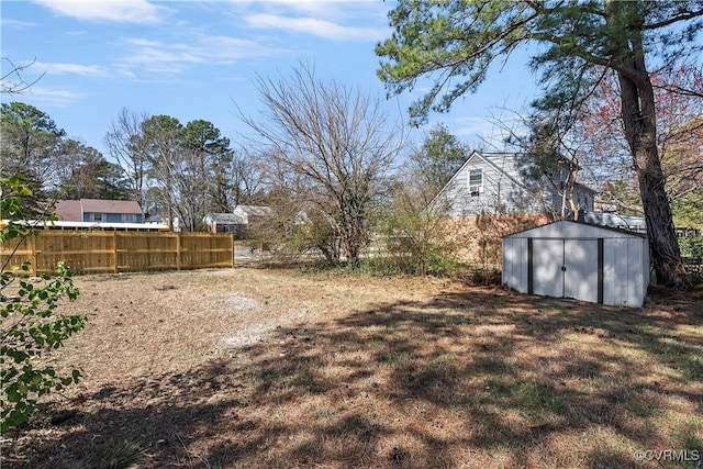 view of yard featuring an outbuilding, a storage unit, and fence