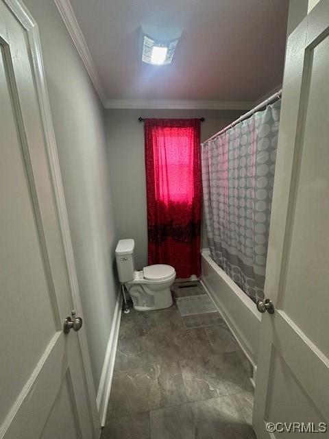 bathroom featuring toilet, baseboards, shower / bath combo, and ornamental molding