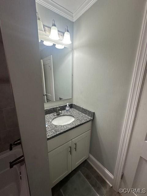 bathroom with baseboards, vanity, and crown molding