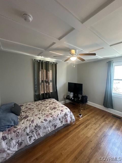 bedroom with wood finished floors, baseboards, coffered ceiling, beam ceiling, and ceiling fan