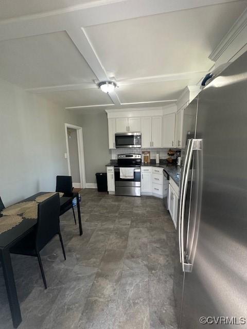 kitchen featuring stainless steel appliances, dark countertops, and white cabinets