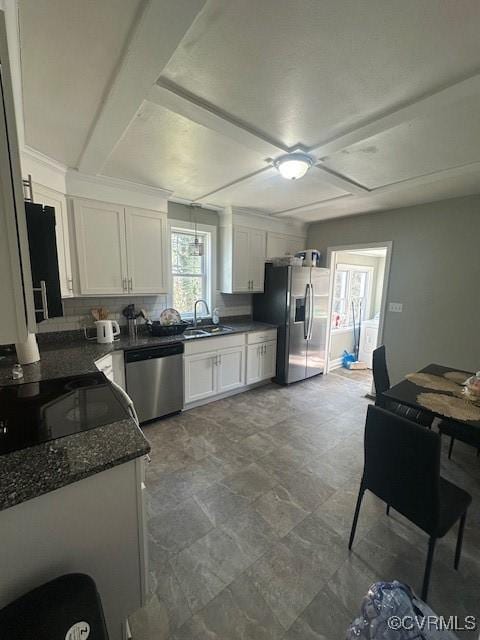 kitchen featuring a sink, decorative backsplash, appliances with stainless steel finishes, and white cabinets