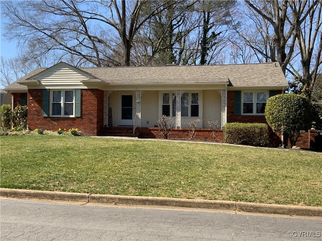 ranch-style house featuring brick siding, a front yard, and a shingled roof