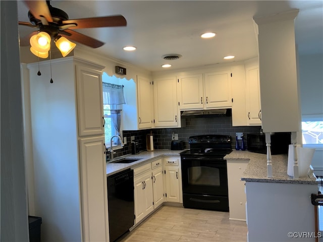 kitchen featuring black appliances, a sink, under cabinet range hood, backsplash, and white cabinets